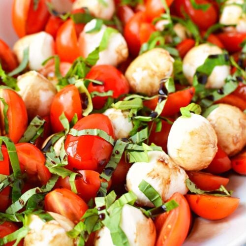 bowl of cherry tomatoes, mozzarella and basil to make caprese salad.