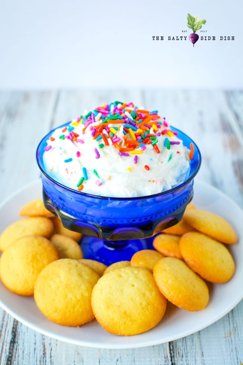 Funfetti Dip Recipe | Funfetti Cake Dip is a super fun, super delicious cake batter dessert dip waiting to be dunked with graham crackers or Nilla Wafers. Layers on the sprinkles and let's get Dipping! #dip #dessertdip #dessert #appetizer #party #parties #dips funfetti cake batter dip recipe in a bowl with sprinkles on top ready to serve at a birthday party