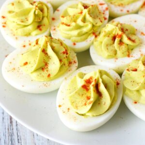 best avocado deviled eggs on a plate with paprika