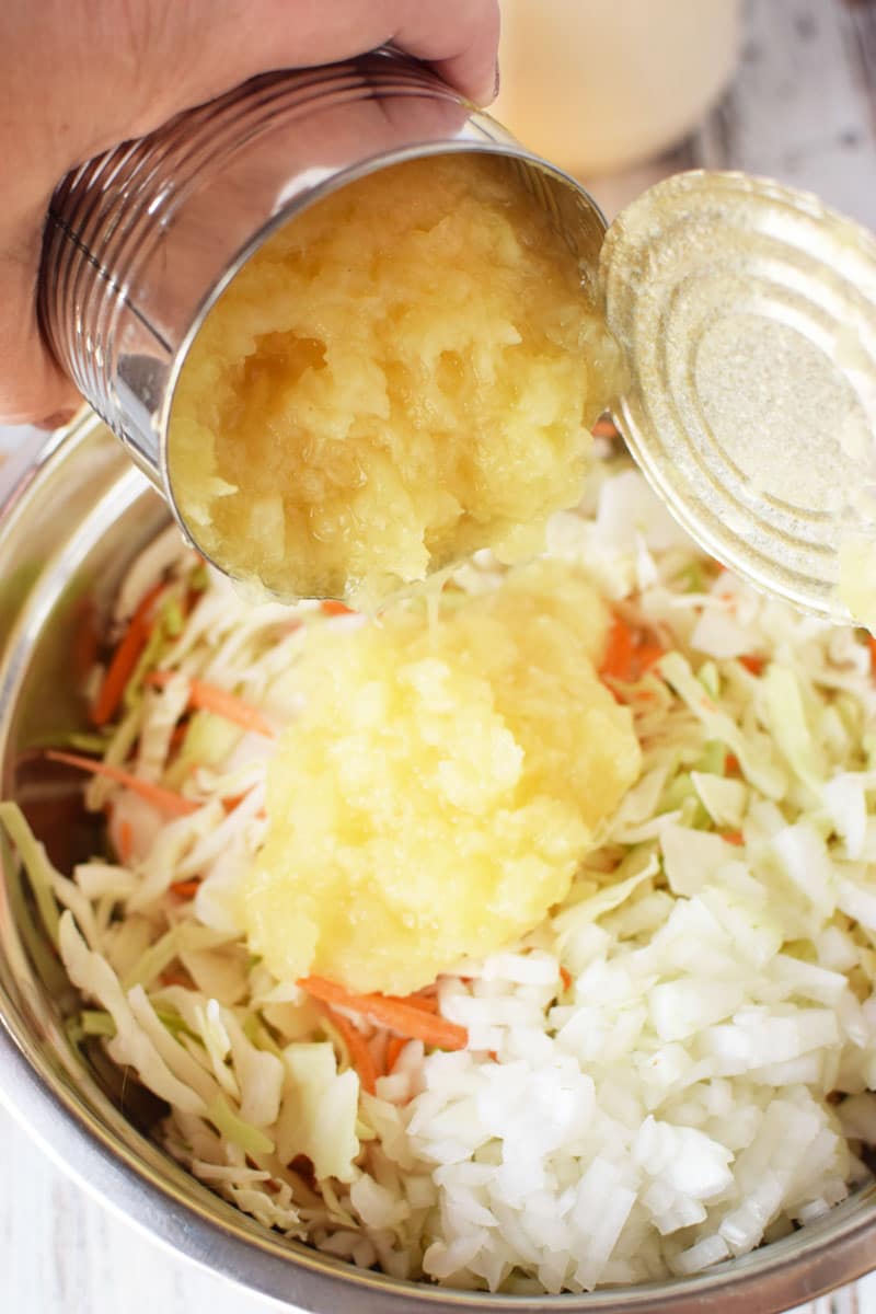 pineapple being drained and added to coleslaw mixture