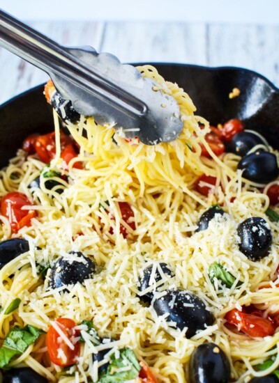 caprese pasta in tongs.