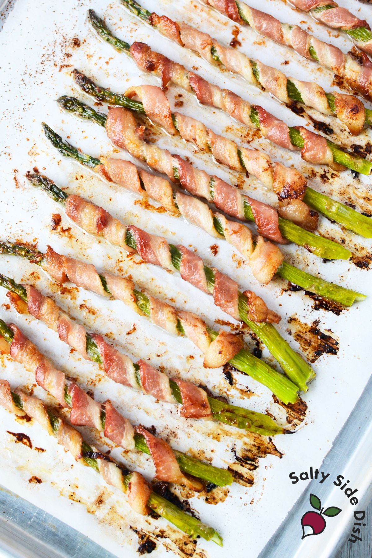 Bacon wrapped asparagus oven baked until crispy arranged on white platter ready to serve