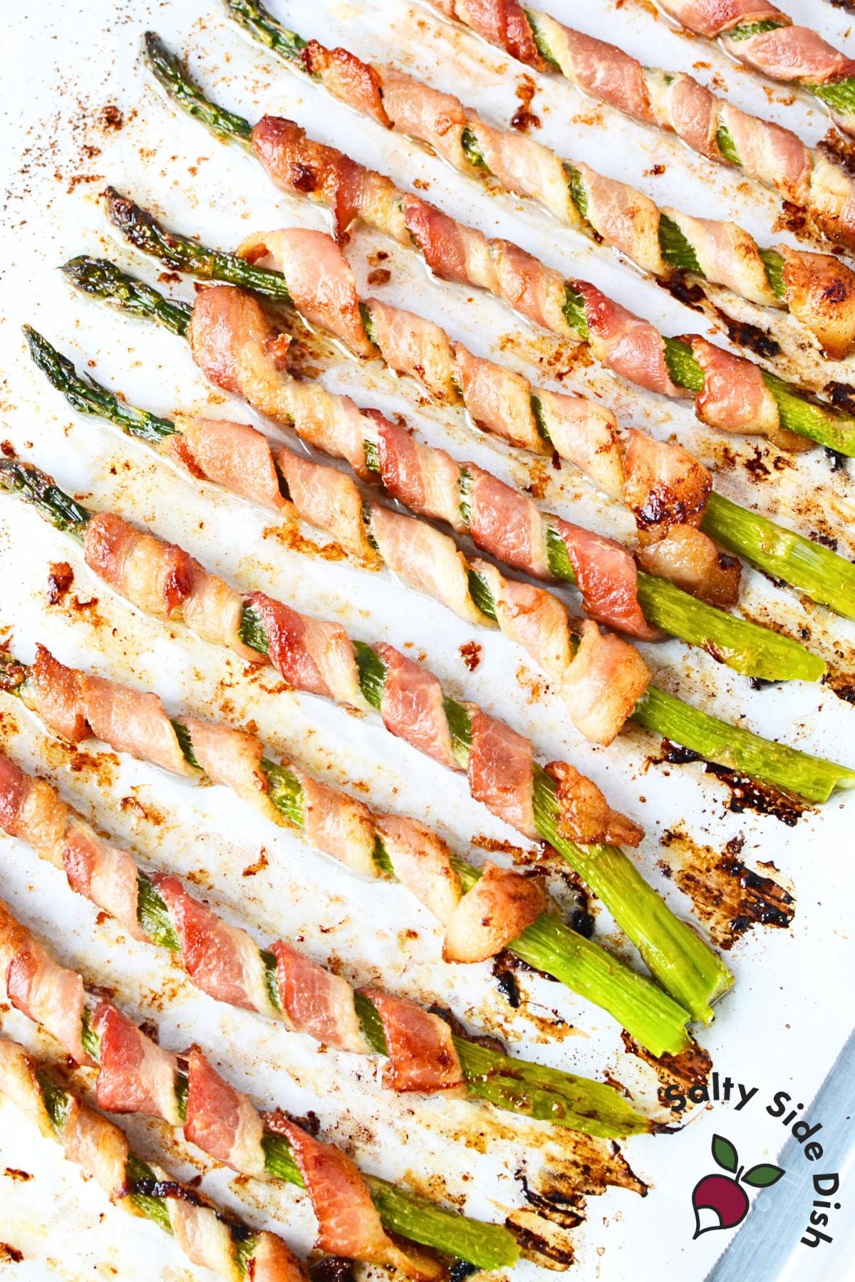 Bacon wrapped asparagus oven baked until crispy arranged on white platter ready to serve