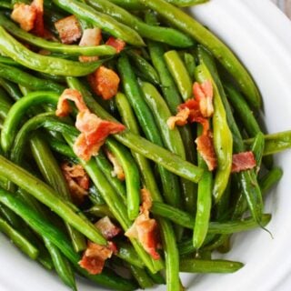 green beans and bacon on a white serving tray