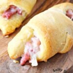 close up of ham and cheese crescent roll on a cutting board.