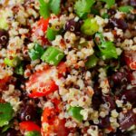 black bean quinoa salad on a white plate with fresh cilantro