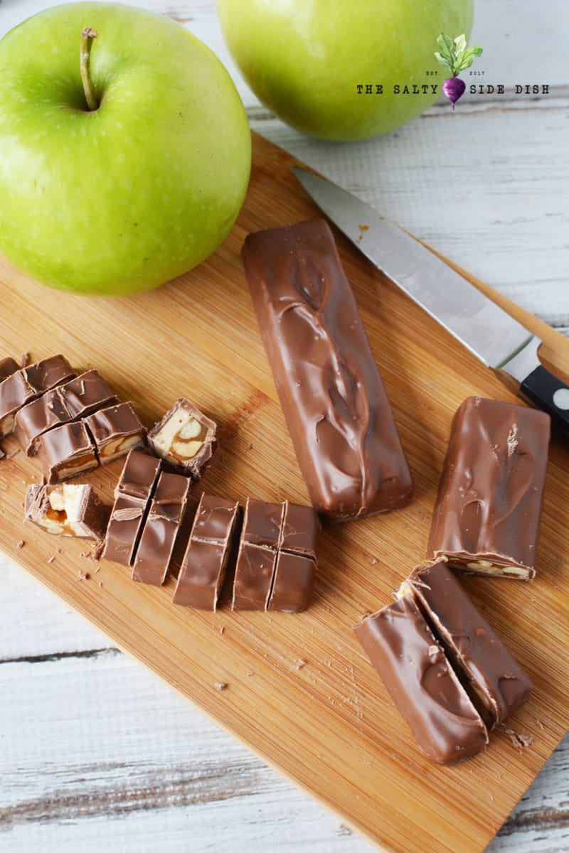 Snicker Apple Salad with white chocolate pudding and whipped topping, loads of full sized cut up Snickers Bars, an amazing dessert salad } Ultimate Potluck Salad! #snickerssalad #applesalad #snickers #fluffsalad #dessertsalad #potluck #partyfood #saltysidedish snickers bars cut up and ready to add to snickers bar salad