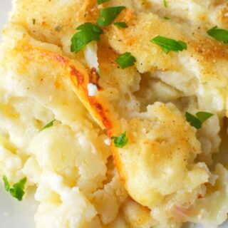 cauliflower au gratin piled on a white plate.