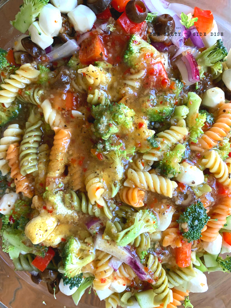 Tri Color Rotini Pasta with Italian Dressing, crunchy fresh vegetables and soft Mozzarella cheese #pastasalad #saladsidedish #sidedish #pasta #recipes fresh homemade curly pasta with fresh broccoli, vegetables and cheeses in a bowl and ready to serve