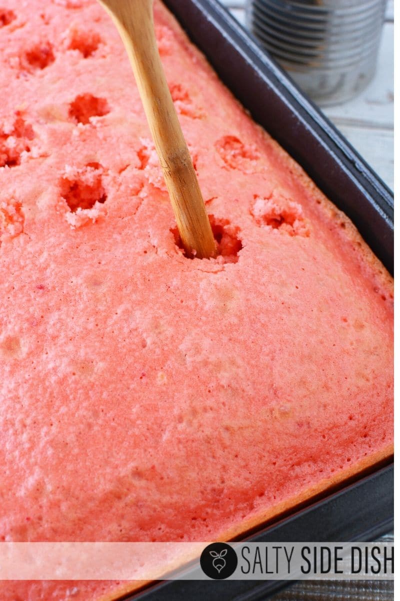 Strawberry Poke Cake with Sweetened Condesnsed milk, whipped topping, and loads of strawberries! #pokecake #pokecakes #cakes #dessert #strawberries #strawberrypokecake #holiday #july4th #valentinesdayrecipes Use a wooden handled spoon to make poke cake