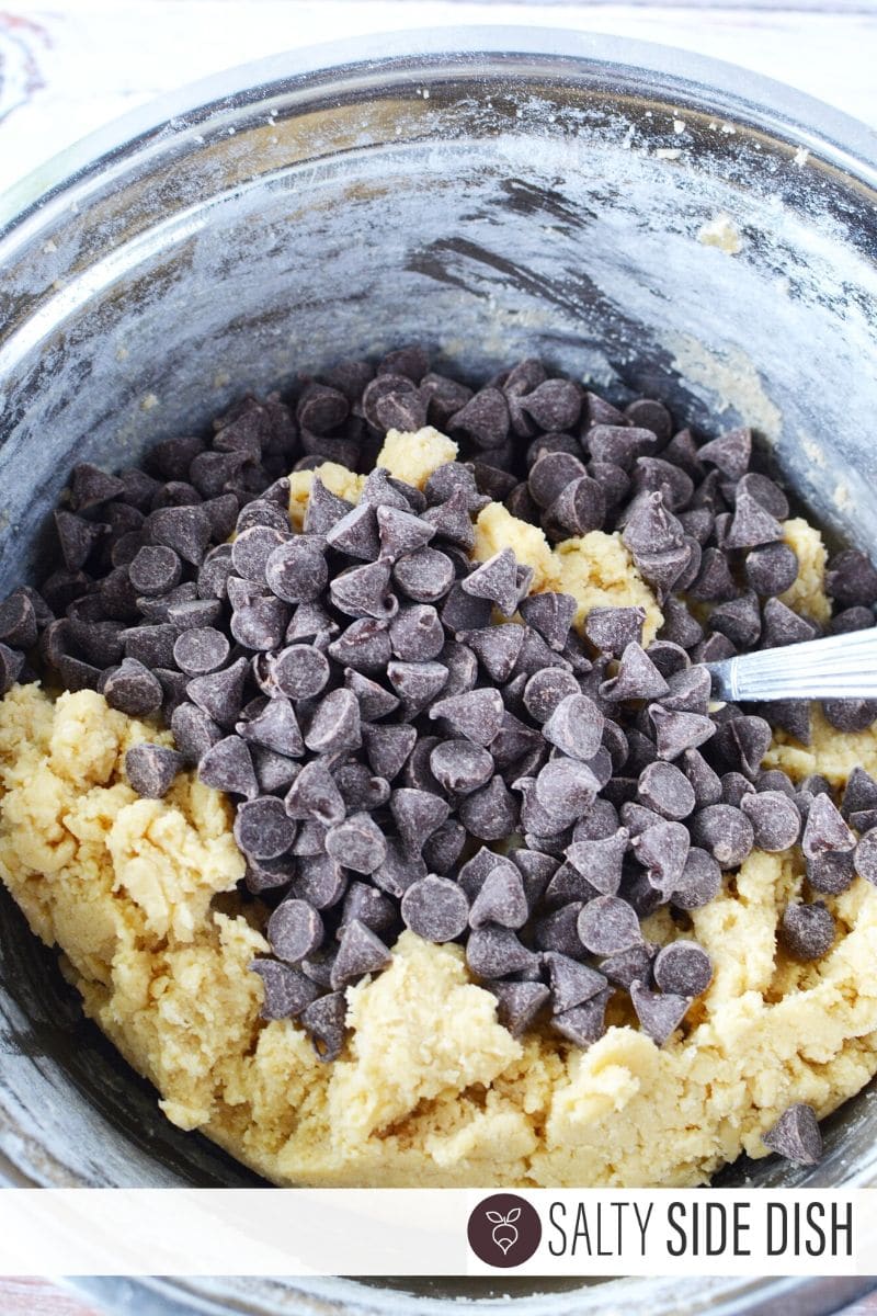 Chocolate Chips dumped on dough in a bowl