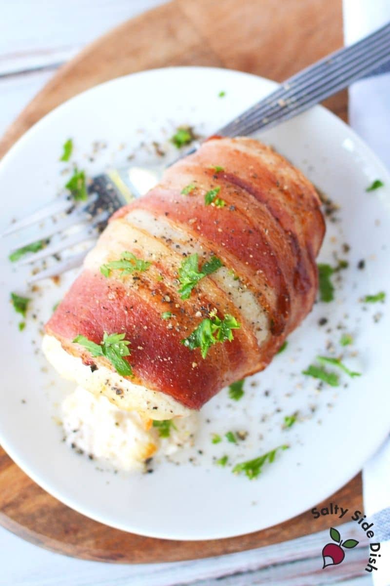 air fryer air crisp bacon wrapped and stuffed chicken on a plate with parsley