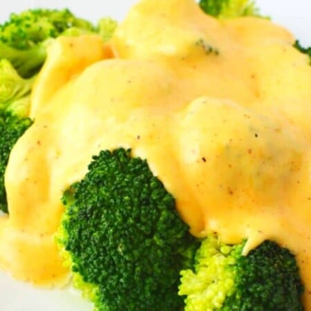 cheese sauce poured over broccoli