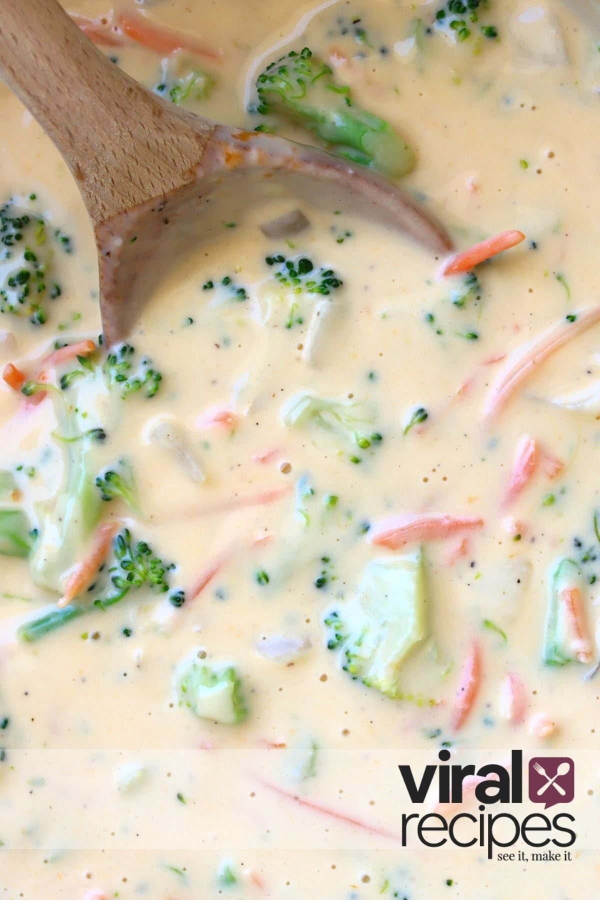 broccoli cheddar soup being stirred with a wooden spoon