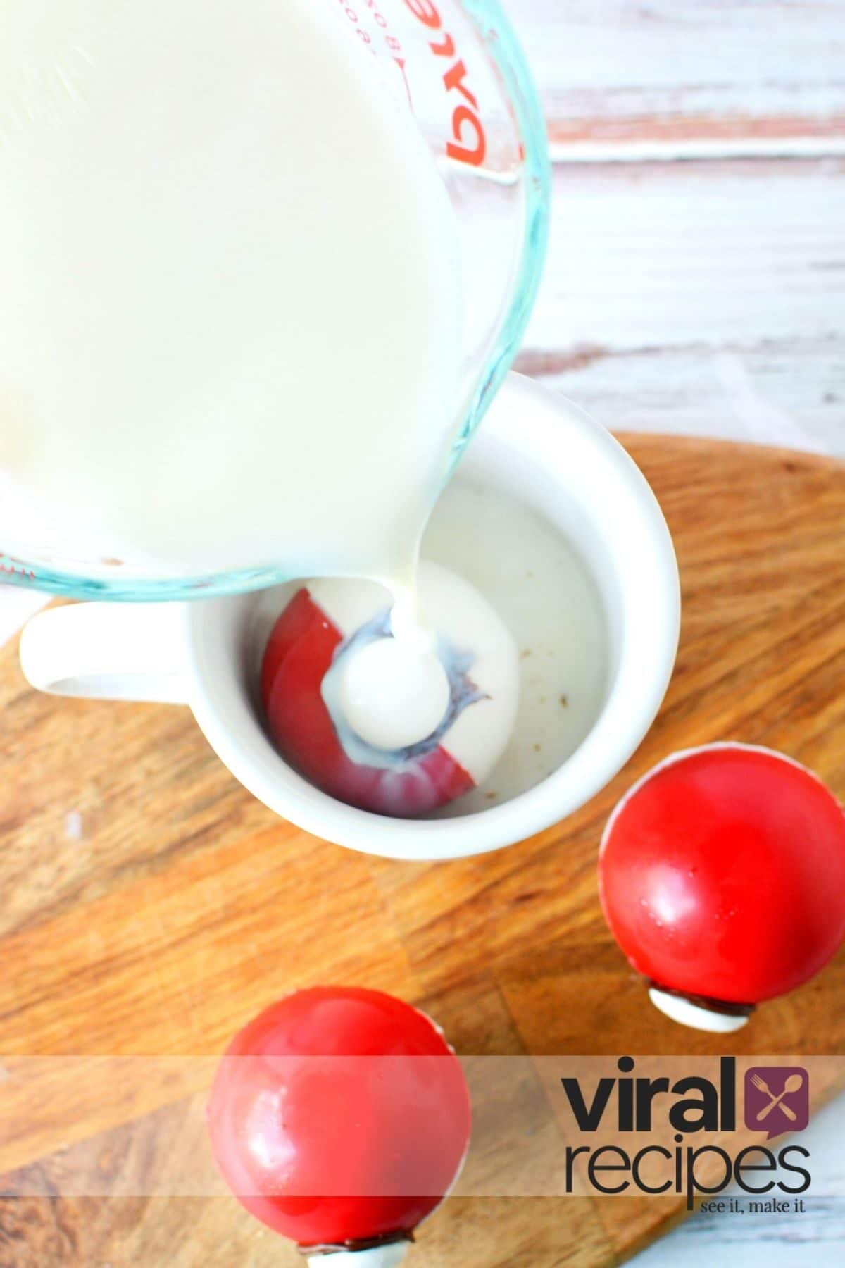 pouring hot milk on a hot chocolate bomb