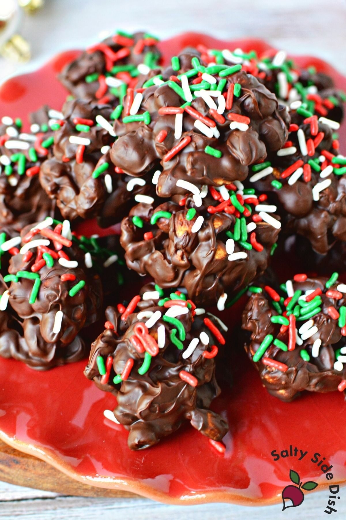 huge pile of chocolate peanut clusters on a red plate. 