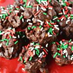 huge pile of chocolate peanut clusters on a red plate.
