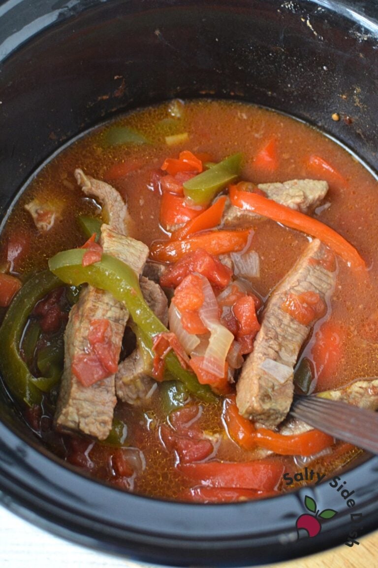 beef sirloin, bell peppers, and onions in a slow cooker.
