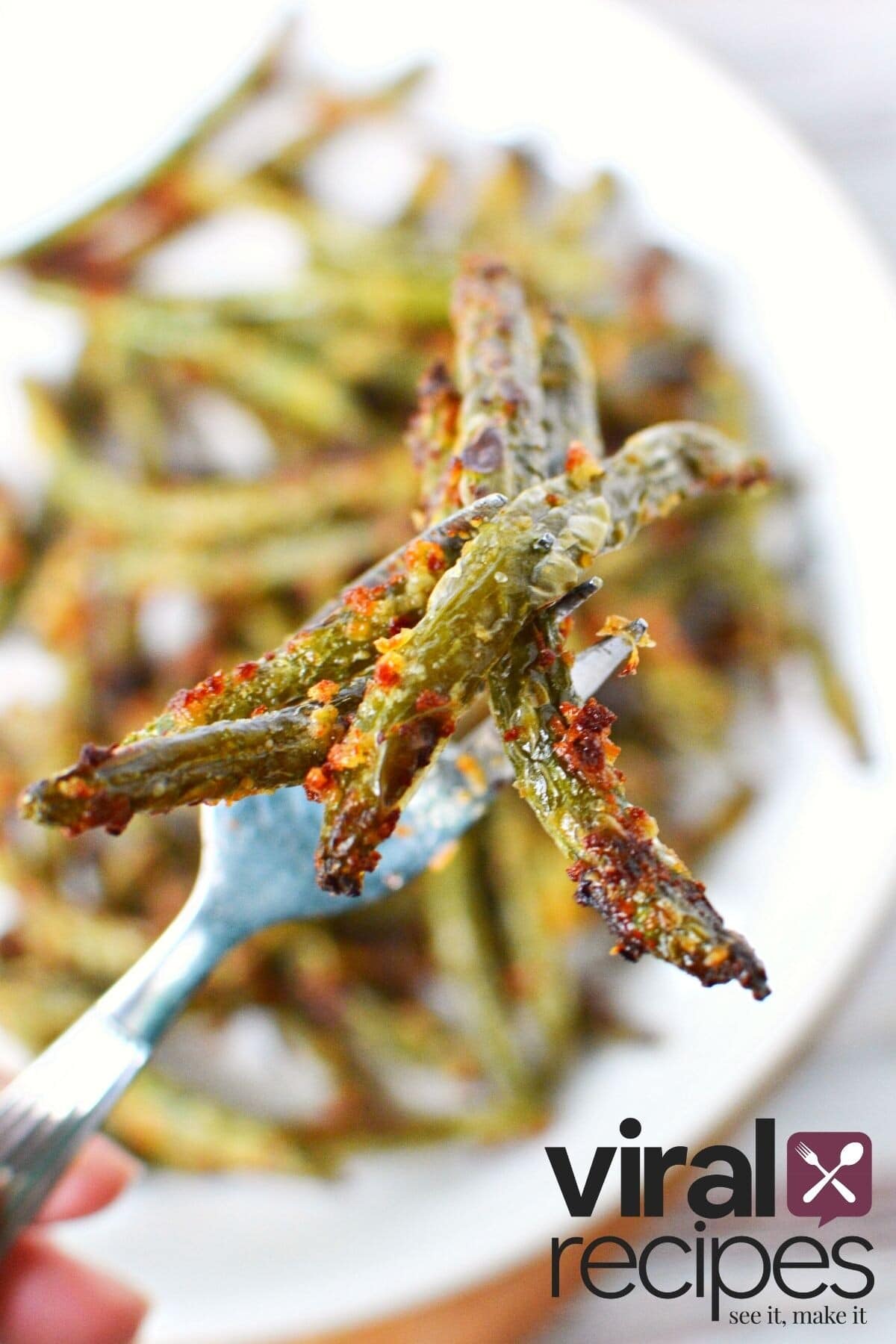 parmesan and mayo green beans in air fryer on a fork.