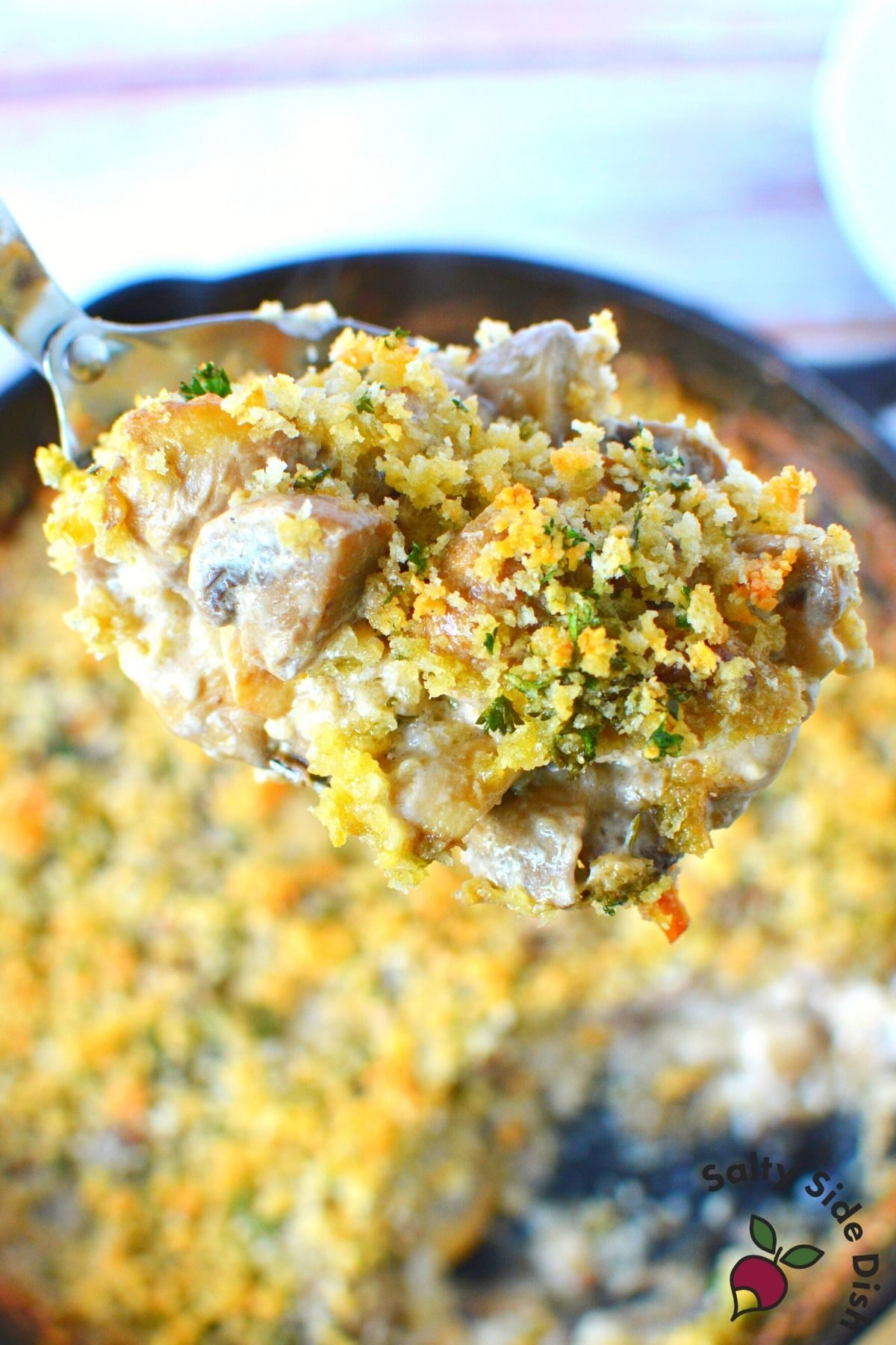 scoop of mushroom bake in a cast iron pan.