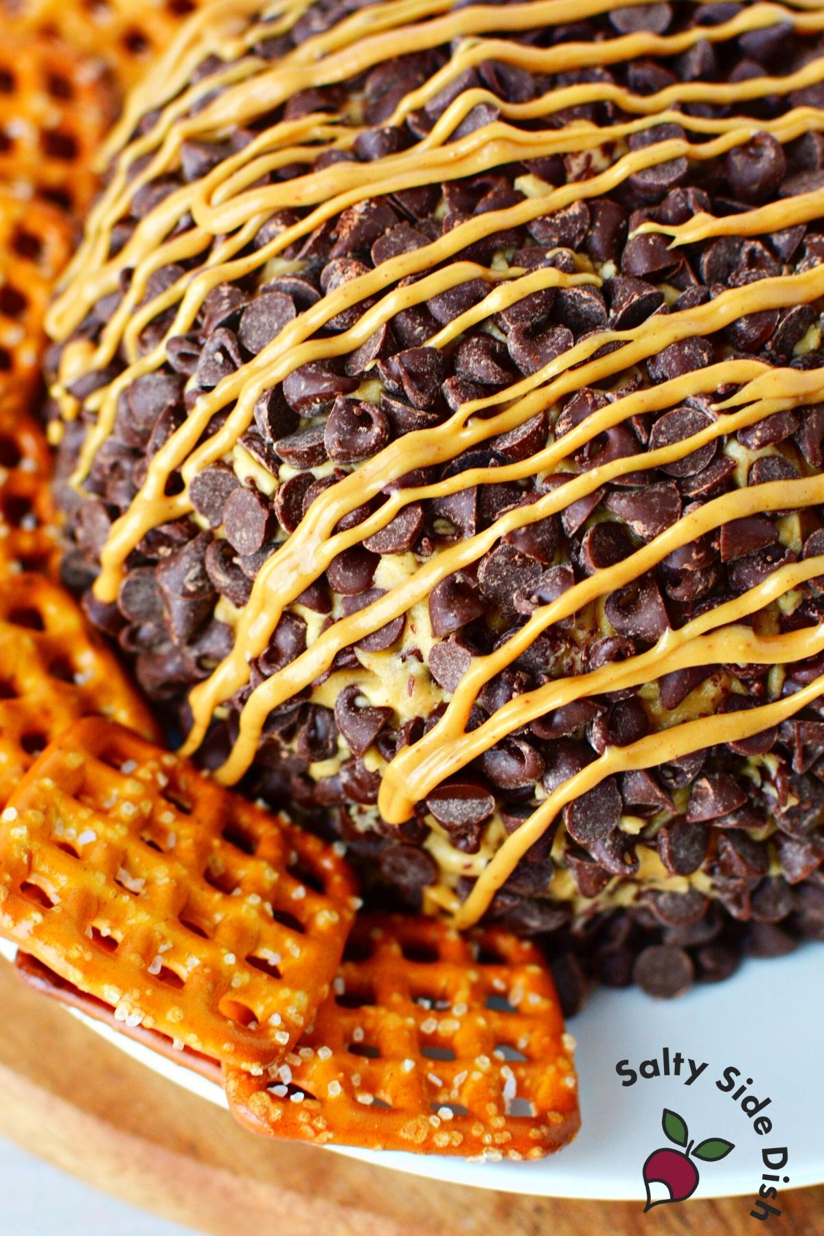 cheeseball on a plate with pretzel dippers.