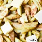 sliced raw apples with butter inside an uncooked pie crust.