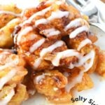 apple cinnamon cinnamon rolls on a white plate with a fork.