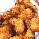 pile of popcorn chicken on a plate with ranch dressing.