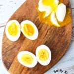 A soft-set egg, a medium egg, and a hard-boiled egg on a cutting board.