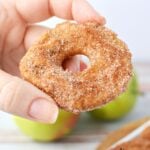 holding a freshly coated slice of fried apple.