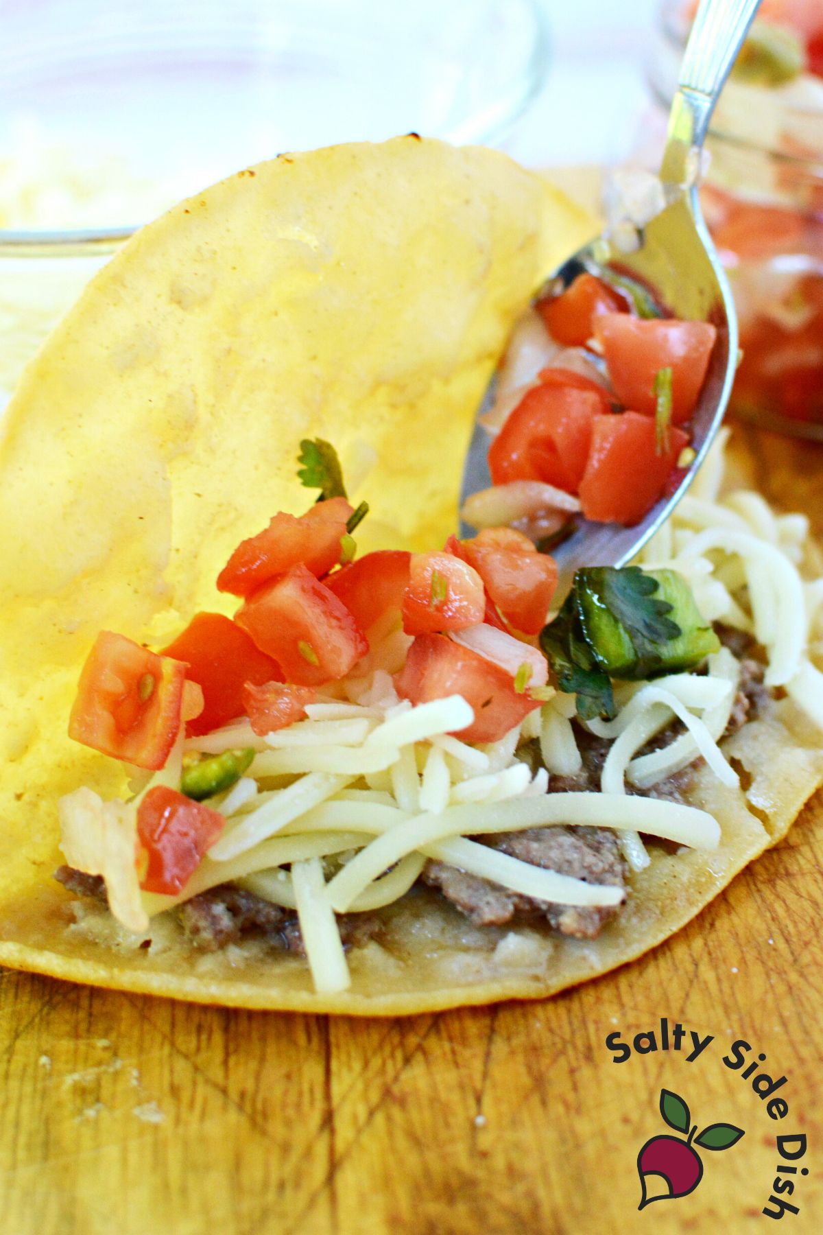 adding toppings to a fried taco.