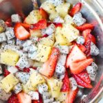 mixing dragon fruit salad in a bowl.