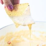tortilla dripping with cheese dip.