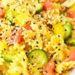 recipe for cucumber and bell pepper pasta salad in a white serving bowl for a bbq.