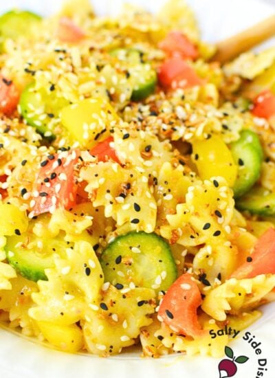 recipe for cucumber and bell pepper pasta salad in a white serving bowl for a bbq.