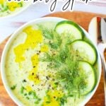 Fresh cucumber gazpacho served in a bowl with dill and chives.