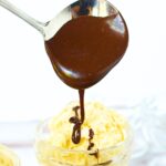 hot fudge being poured over vanilla ice cream.