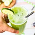 Serving a glass of cucumber juice with a sprig of mint.