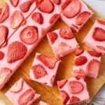 strawberry fudge recipe with pieces cut up on a cutting board.