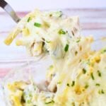 ooey gooey cheese on a spoon with baked pasta and chicken.