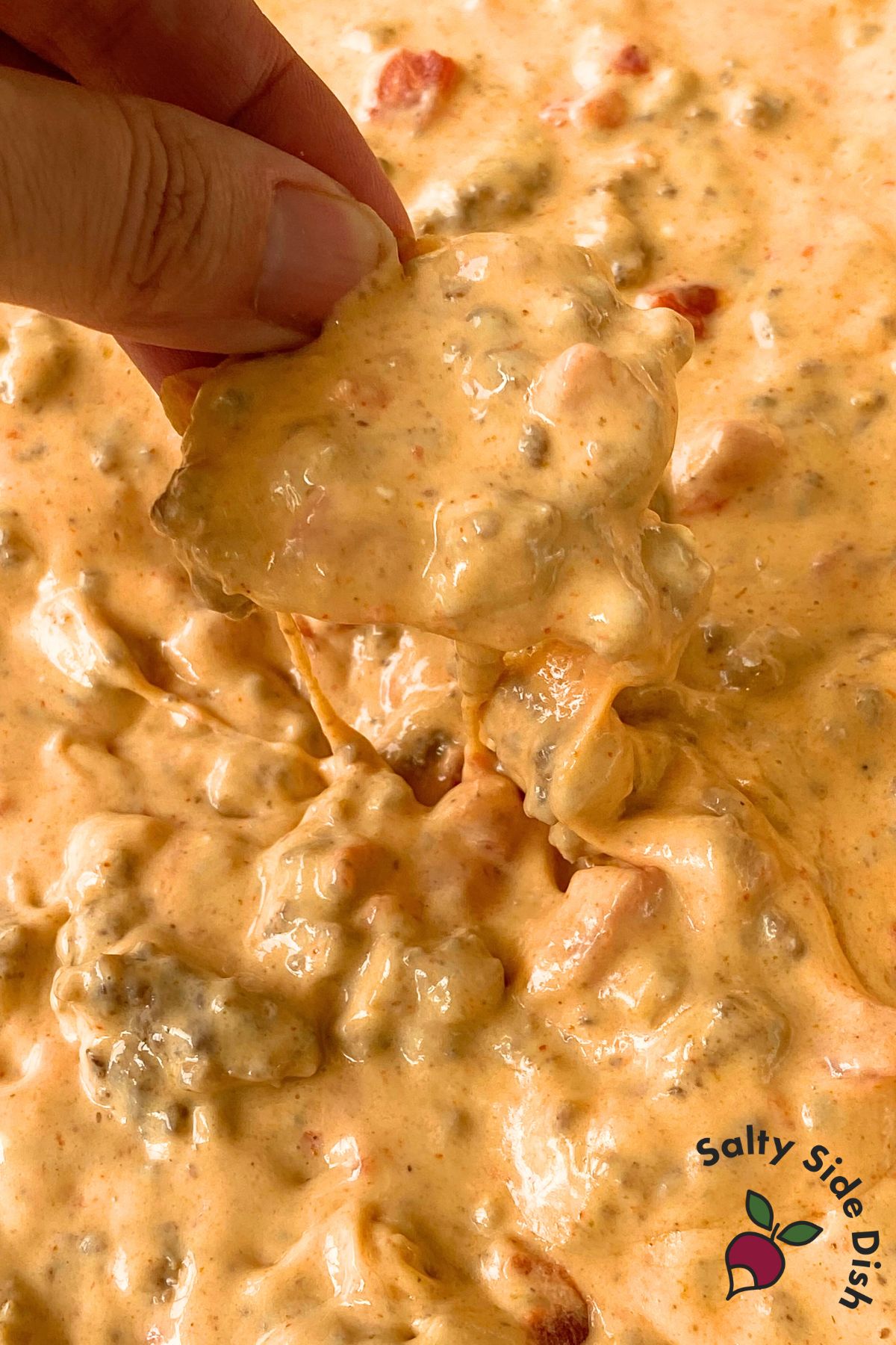dipping tortilla chip in a cheese dip.