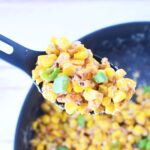 sweet and spicy corn in a spoon getting ready to serve.