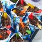 A full tray of Oreo dirt in a bag desserts topped with crushed cookies and gummy worms.