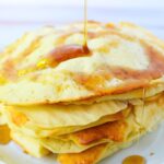 stack of air fryer pancakes with syrup drizzled on top.