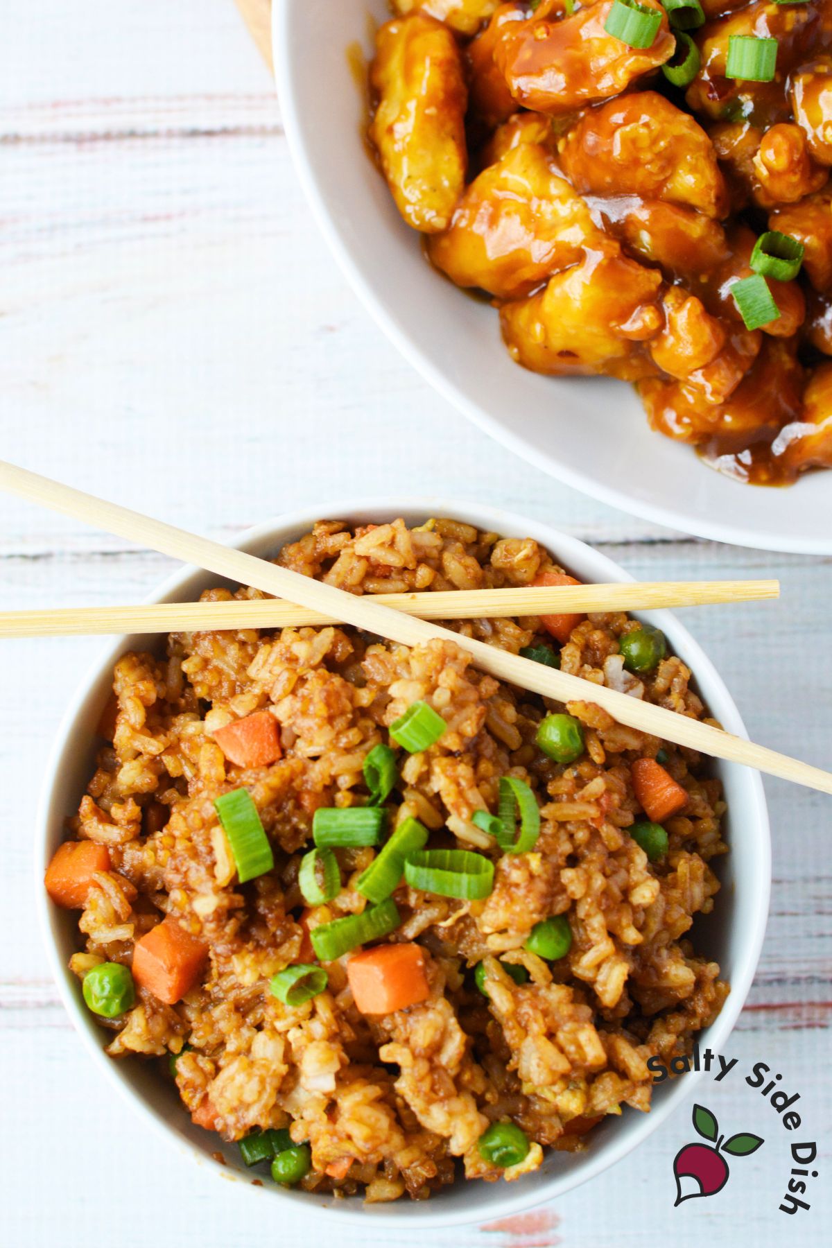 Jasmine fried rice served in a bowl next to sweet and sour chicken.