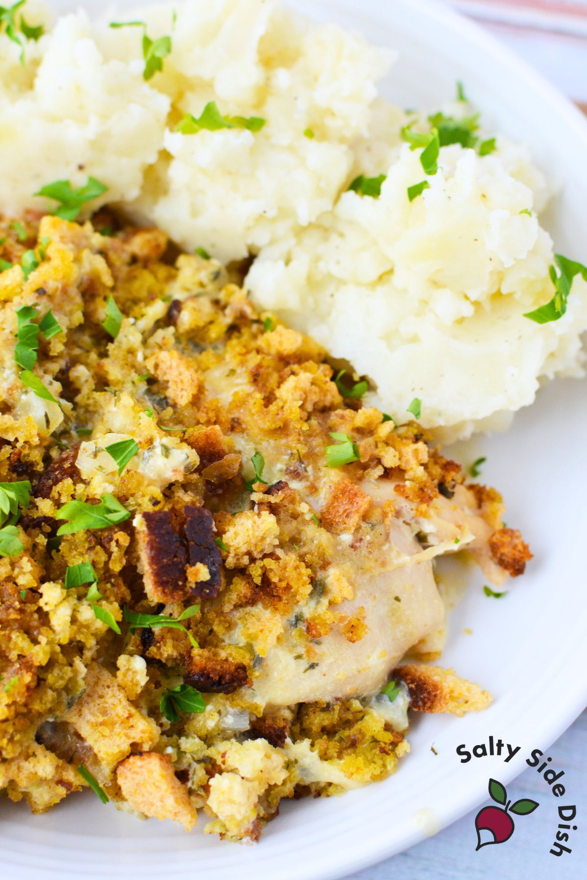 Closeup of crockpot chicken and dressing topped with golden stuffing and fresh parsley
