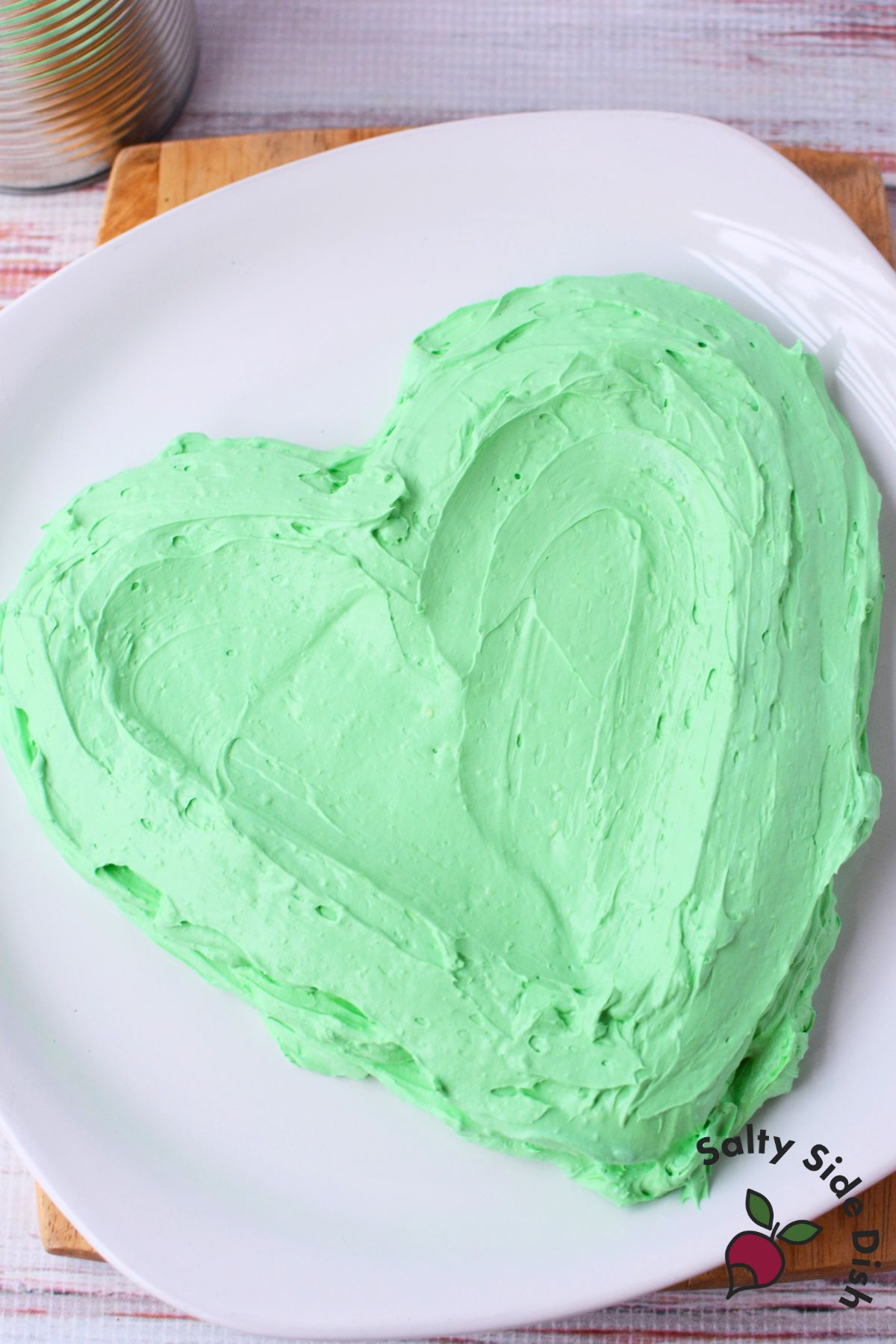 No-bake green cheesecake dip shaped into a heart for Grinch-themed holiday dessert