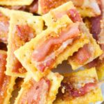 Pile of golden club crackers topped with crispy brown sugar bacon, ready for a party tray