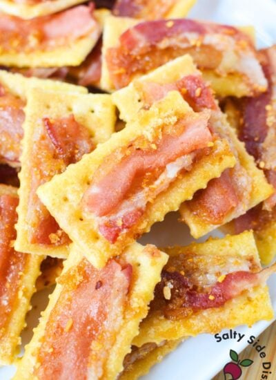 Pile of golden club crackers topped with crispy brown sugar bacon, ready for a party tray