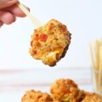 Holding a single Rotel sausage ball appetizer with a toothpick